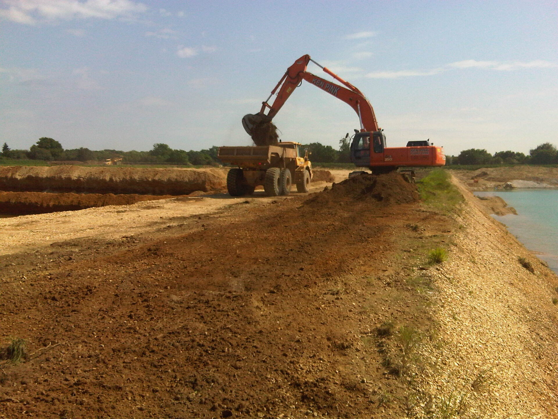 Large bucket loader transferring groundwork into a flatbed truck